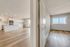 Bright open-concept living space with elegant hardwood floors, modern kitchen, and large windows offering a scenic view.