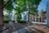Scenic apartment complex with lush greenery and stone pathways in a serene natural setting.