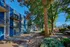 Charming apartment complex with vibrant blue accents, surrounded by lush greenery and serene pathways.