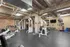 Modern industrial-style fitness center with exposed brick walls, sophisticated gym equipment, and ample space for workouts.