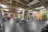 Modern apartment gym featuring state-of-the-art fitness equipment against an industrial-style brick backdrop.