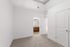 Bright and inviting bedroom with plush carpet, open closet, and a view into the stylish bathroom with modern fixtures.