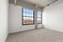 Bright and modern loft space with large industrial-style windows offering a stunning city view, perfect for urban living.