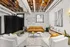 Chic industrial-style lounge with exposed beams, cozy seating, and contemporary decor.
