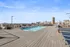 Stunning rooftop pool with panoramic city skyline views and modern lounge seating on a sunlit deck.