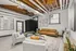Chic and modern lounge area featuring a leather sofa, contemporary artwork, and industrial-style ceiling with exposed beams.