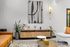 Modern and inviting apartment lobby featuring elegant seating with a warm leather couch, stylish abstract art, and lush greenery for a welcoming ambiance.