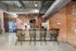 Chic industrial-style kitchen with exposed brick walls, modern bar seating, and stainless steel appliances, perfect for trendy living.