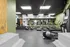 Modern gym facility equipped with multiple treadmills and cardio machines, featuring sleek design and vibrant green accents.