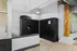 Modern apartment lobby featuring secure Luxer One package lockers, exposed brick walls, and stylish wood flooring.