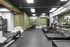 Modern fitness center with multiple treadmills, exercise bikes, and sleek green accents, ideal for a comprehensive workout experience.
