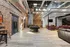 Industrial chic loft space boasting exposed brick walls, a stylish billiards table, and comfortable lounge seating under high ceilings.