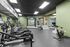 Modern fitness center with state-of-the-art exercise equipment, sleek green walls, and ample natural light, perfect for an invigorating workout.