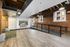 Modern apartment lobby featuring exposed brick walls, sleek glass partition, and large windows offering natural light.