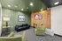 Chic lounge area featuring modern green armchairs, a sleek black sofa, and vibrant wall art.