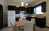 Inviting kitchen with modern dark cabinetry, sleek appliances, and a cozy dining area for four.