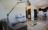 Elegant open-plan living area with modern furniture, a sleek glass coffee table, and a cozy dining space near the kitchen. Ideal for stylish urban living.