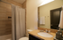 Elegant bathroom with modern fixtures, sleek granite countertop, and stylish shower curtain creating a serene oasis.