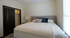 Cozy bedroom with a plush bed, stylish headboard, and inviting soft lighting, perfect for relaxation.