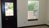 Sunny room with stylish dark door and window view of lush greenery.