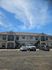 Charming apartment complex under a bright blue sky, featuring convenient parking and elegant exterior design.