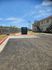 Charming apartment exterior with convenient outdoor trash disposal area and clear blue skies.