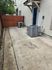 Charming outdoor patio with modern air conditioning units and stylish wooden fencing, perfect for relaxation and privacy.
