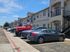 Modern apartment complex with convenient parking, showcasing attractive two-story architecture under a clear blue sky.