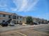 Charming apartment complex featuring modern two-story buildings, ample parking, and a bright blue sky backdrop, ideal for comfortable living.