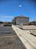 Sunny exterior view of modern apartments with convenient parking and clear blue skies, perfect for comfortable living.