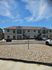 Modern apartment building with charming architecture and convenient parking under a bright blue sky.