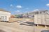 Inviting apartment complex with modern architecture, ample parking, and communal mailboxes under a bright blue sky.