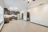 Modern open-concept kitchen and living area with sleek dark cabinets, stainless steel appliances, and ample natural light.