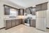 Elegant kitchen with dark wood cabinets, modern stainless steel appliances, and granite countertops offering a sleek culinary space.