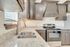 Modern kitchen with sleek granite countertops, stainless steel sink, and elegant dark wood cabinetry adorning a stylish oven.