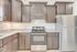 Modern kitchen with sleek stainless steel appliances, elegant dark wood cabinetry, and granite countertops, creating a sophisticated culinary space.