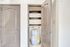 Chic utility closet with built-in shelving and modern water heater, perfect for efficient storage solutions.