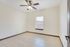 Bright and airy room with sleek tiled floors and modern ceiling fan, perfect for a cozy living space.