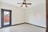 Bright room with tiled floor, ceiling fan, and modern door leading to outdoor space, offering stylish comfort.