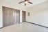 Bright and airy room with modern tile floors, ceiling fan, and chic double closet doors.
