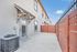 Inviting townhouse exterior with private fenced patio and charming architectural accents, perfect for relaxing or entertaining.