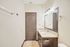 Elegant bathroom featuring a granite countertop, large mirror, and stylish lighting, creating a bright and inviting space.