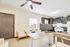 Modern apartment with a stylish open-plan kitchen and living space, featuring sleek cabinets, a spacious work desk, and cozy seating area, perfect for comfortable living.
