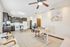 Modern open-concept kitchen and living space featuring sleek dark cabinets, elegant dining area, and a stylish home office corner.