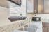 Elegant kitchen with polished granite countertops, modern stainless steel sink, dark wood cabinetry, and natural light streaming through window blinds.