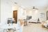 Bright and inviting office space with modern furnishings, featuring a stylish white desk, comfortable chairs, and natural light enhancing a cozy atmosphere.