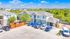 Charming modern apartment complex with lush greenery, ample parking, and inviting communal spaces under a bright, clear sky.