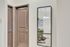 Inviting apartment hallway with elegant brown doors and a stylish dining area reflected in a wall mirror.