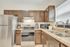 Modern kitchen with stylish dark wood cabinets, stainless steel appliances, and granite countertops featuring a bright and inviting atmosphere.