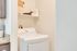 Convenient in-unit laundry room featuring a modern washer with granite countertop and stylish storage basket.